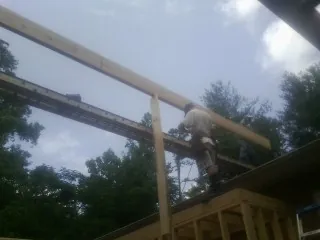 Carpenter setting a ridge beam over a new addition frame — Ice Dam Removal by Roofing Brothers in Stratford