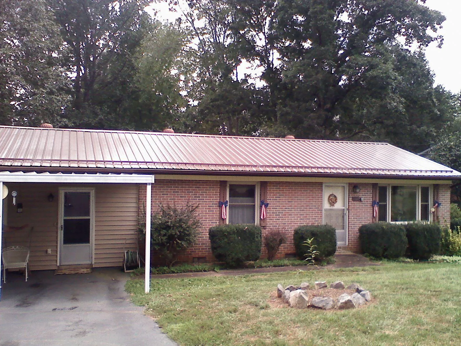 Bronze metal roof and carport on a brick ranch home — Roof Repair work by our crew in Stratford